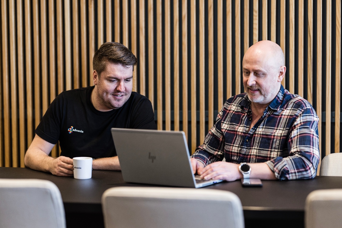 Bilde av to menn som ser på en PC